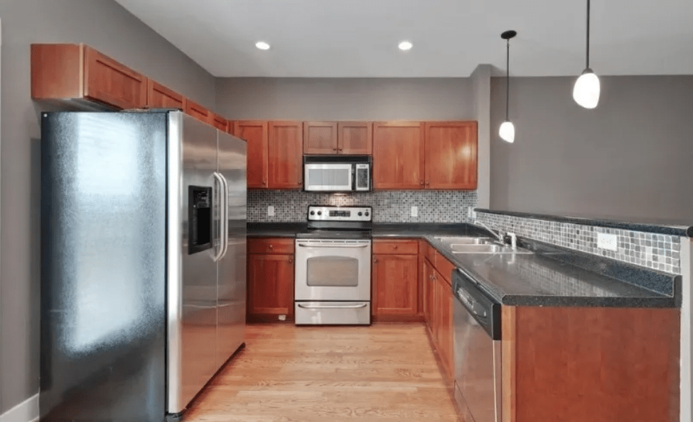 Modern kitchen featuring stainless steel appliances, wooden cabinets, and a sleek countertop. Ideal layout for cooking and entertaining.